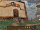 Screenshot from Ultima IX of the player in a suit of armour standing outside a building.