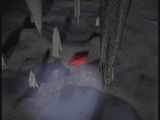A red jewel fragment on the ground among stalactites, stalagmites and puddles