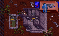 Screenshot from Ultima VII of what appears to be a tomb. A closeup of an drawer appears inset, containing several glowing blue items.